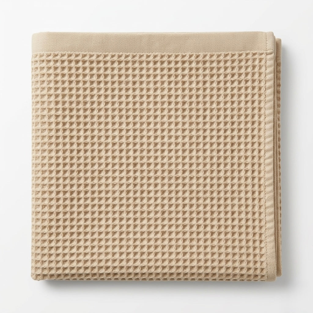 Beige waffle grid bath towel on a white background