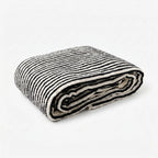 Folded black and white striped bath towel on a white background