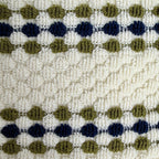Close-up of a textured ath towel with a pattern of blue and green shapes on a beige background