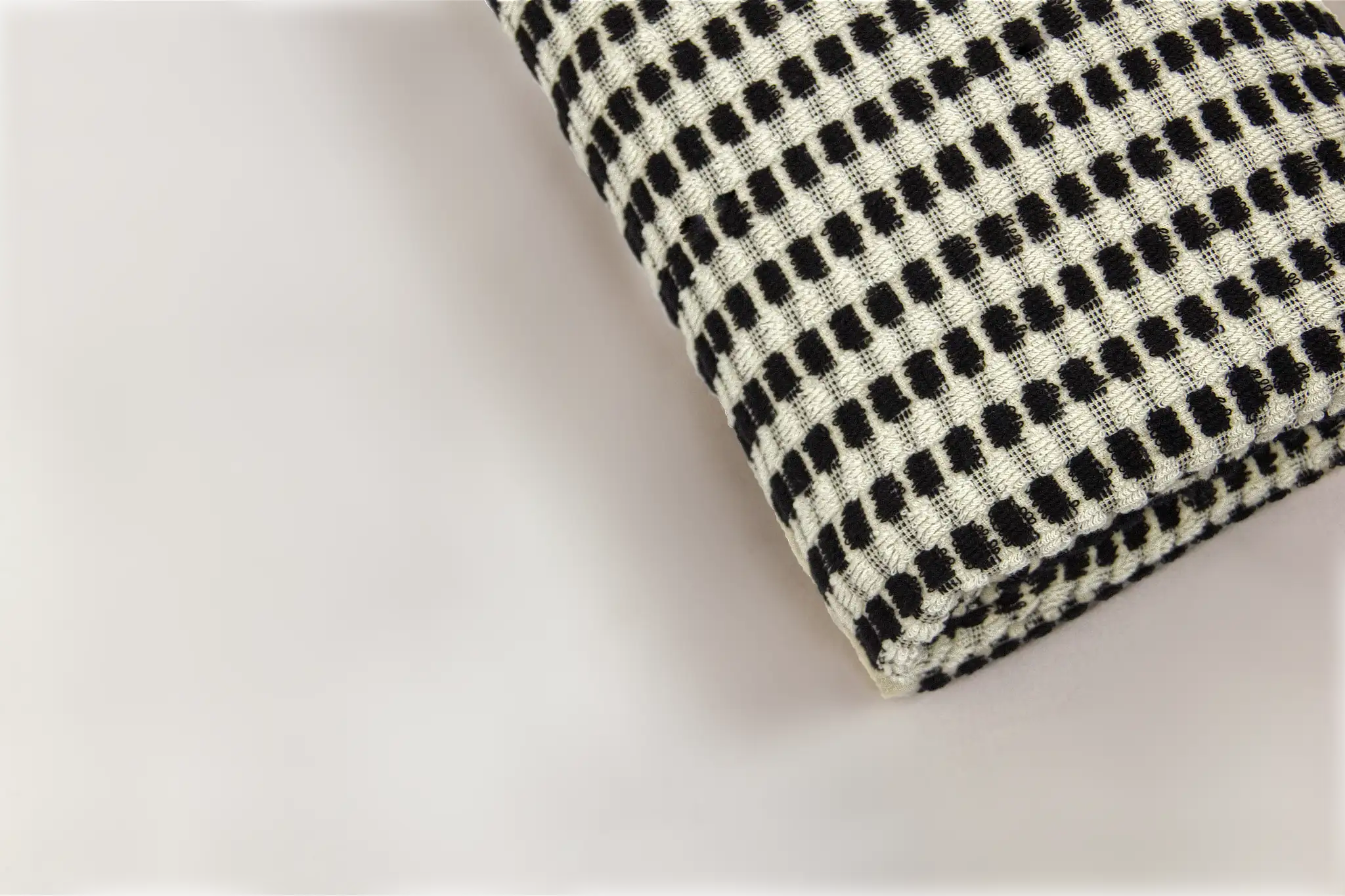 Black and white checkered bath towel on a light gray background