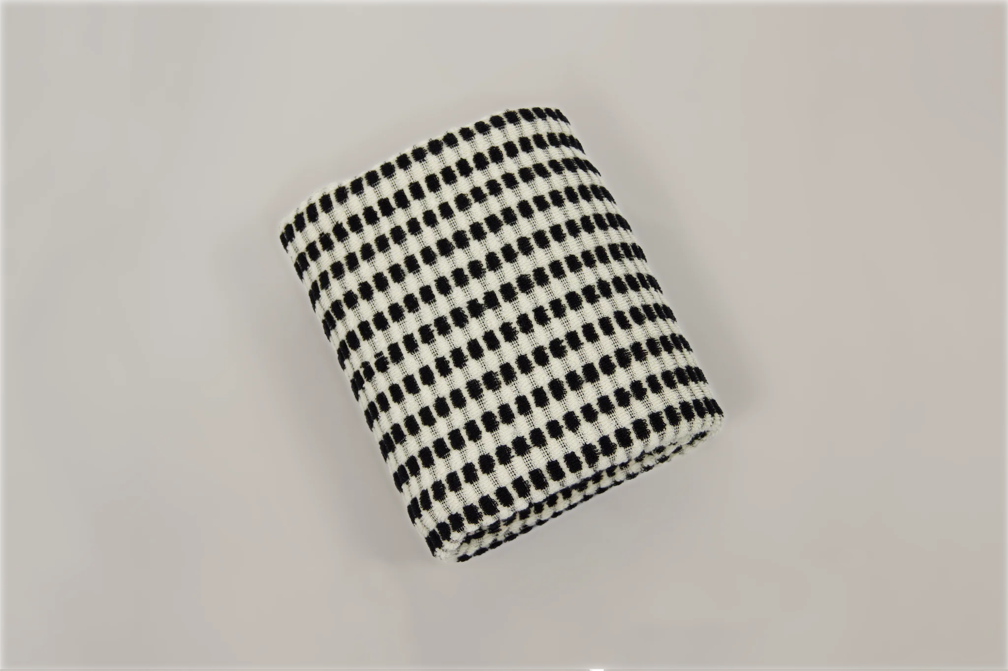Black and white checkered bath towel on a light gray background